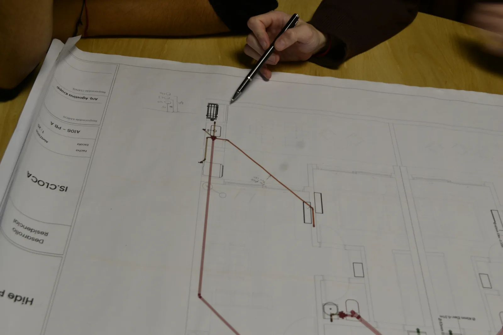 Revisión del plano de instalación cloacal sobre la mesa de trabajo